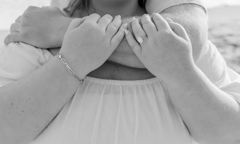 Hands held close on the sand