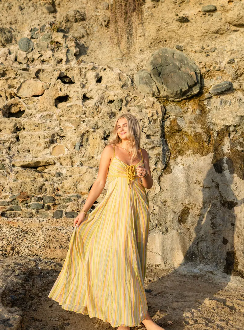 Portrait in a yellow gown against the rocks