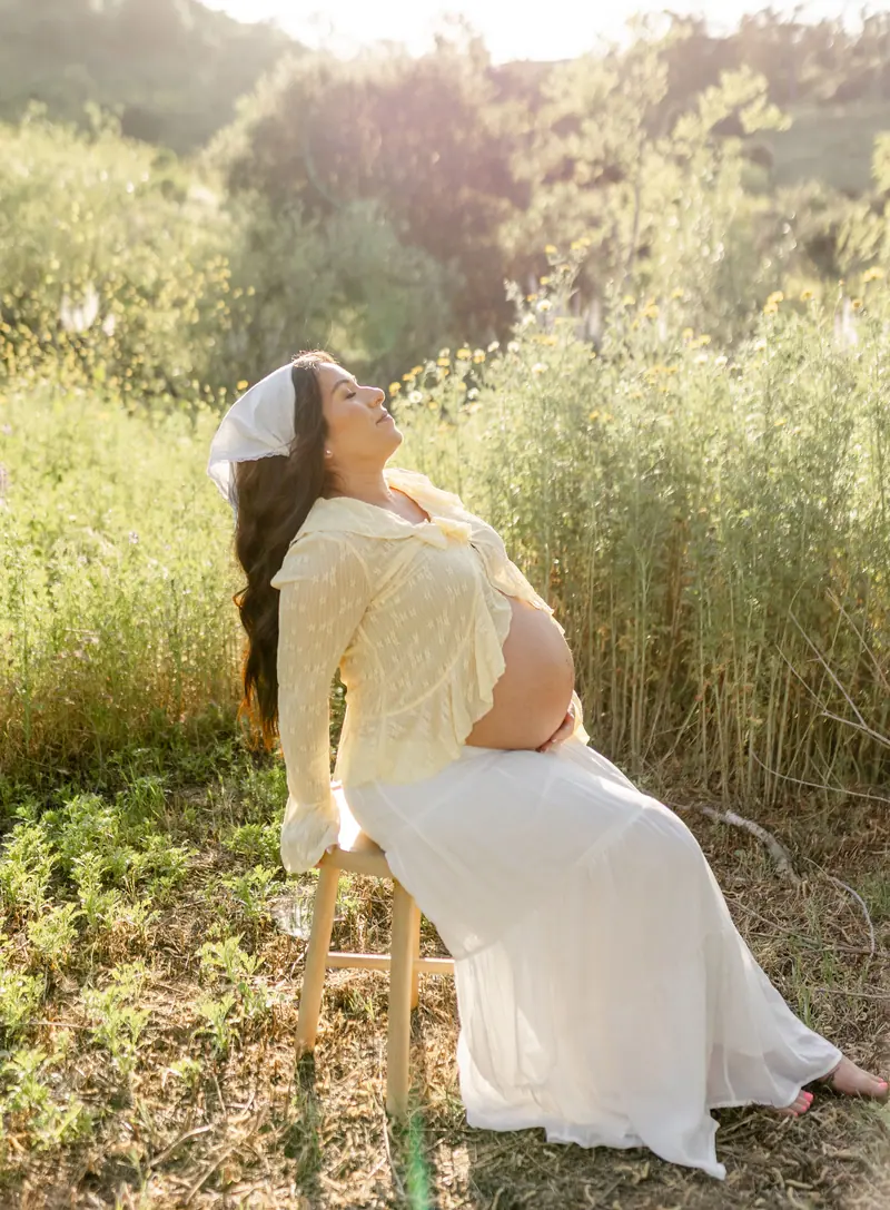 Expecting mother in a field at golden hour