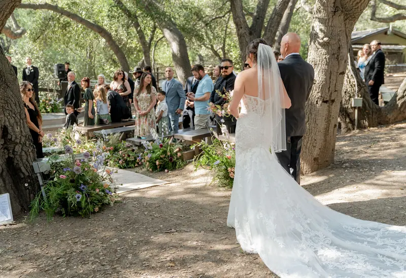 Bride walking the aisle under the oaks